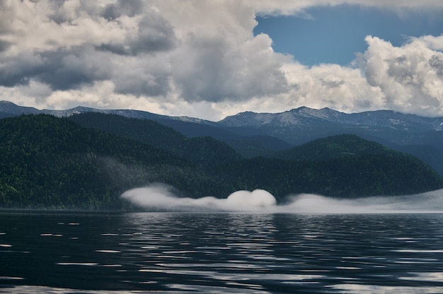 Nevoeiro no vale da montanha. Névoa da manhã sobre o lago nas montanhas Altai.