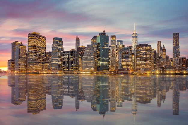 New York City Berühmte Manhattan Skylines zur Abendzeit mit Reflexionen und stimmungsvollen Wolken NYC USA