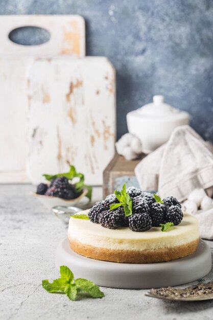 New Yorker Käsekuchen oder klassischer Käsekuchen mit frischen Beeren auf grauem Stein