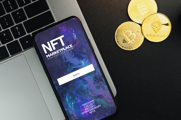 NFT NonFungible Token Marketplace en la pantalla del teléfono inteligente en una mesa negra con monedas de criptomonedas y un entorno de oficina de computadora