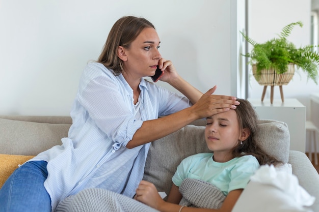 Ängstliche junge Mutter ruft Krankenwagenarzt an, kümmert sich um kranke kleine Mädchen mit Grippe und hoher Temperatur. Besorgte Mutter Kontakttherapeut oder Kinderarzt mit kleiner Tochter fühlen sich krank.