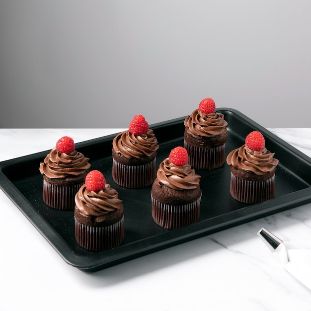 Ângulo alto de deliciosos cupcakes de chocolate com framboesa