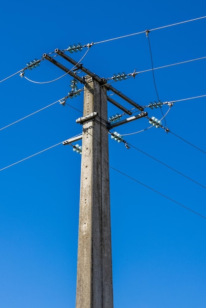 Ângulo baixo vertical de um poste elétrico isolado em fundo azul