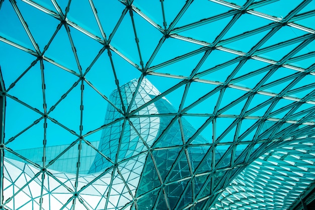Ángulo bajo de techo de vidrio curvo con formas geométricas de edificio moderno diseñado en estilo futurista