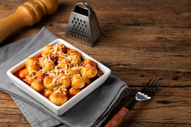 Foto nhoque com molho de tomate e queijo parmesão ralado