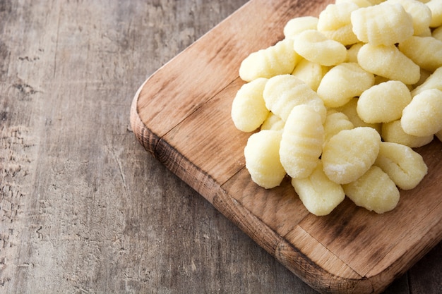 Nhoque de batata crua no espaço da cópia de mesa de madeira