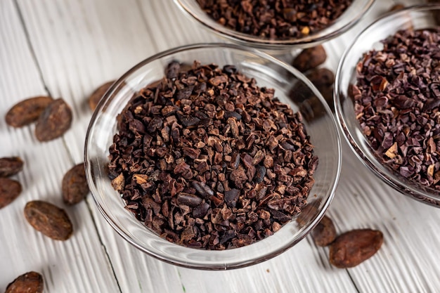 Nibs de cacau com grãos de cacau em fundo de madeira velho