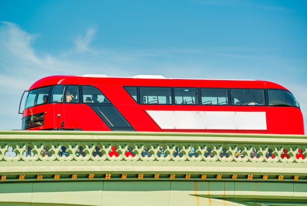 Ônibus vermelho cruzando a ponte da cidade em Londres. Conceito de turismo.