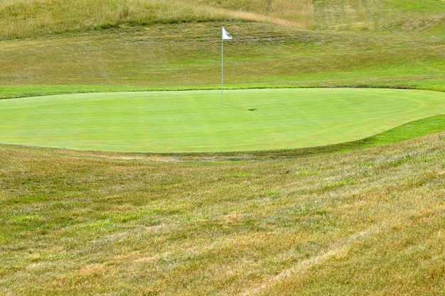 Nice campo de golfe em um dia ensolarado de verão. buraco com uma bandeira. desporto ao ar livre popular.