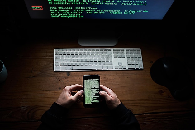 Nicht einmal Ihr Smartphone ist sicher Hochwinkelaufnahme eines nicht identifizierbaren Hackers, der spät in der Nacht einen Computer benutzt