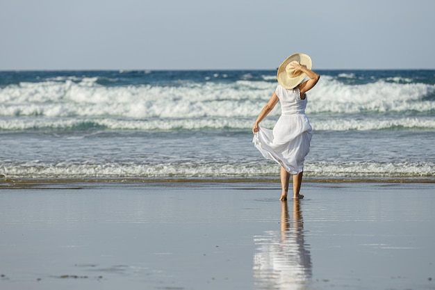 Nicht erkennbare Frau, die das wogende Meer bewundert