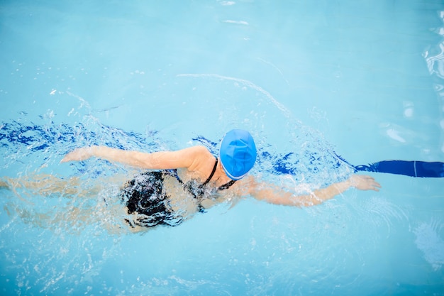 Nicht erkennbare Frau, die im Pool schwimmt