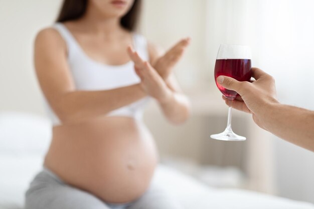 Nicht erkennbare schwangere Frau weigert sich, beschnittenen Wein zu trinken