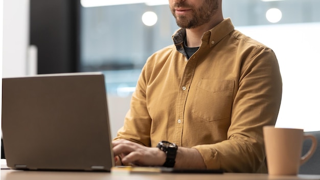 Nicht erkennbarer Geschäftsmann mit Laptop-Computer, der im Büro arbeitet