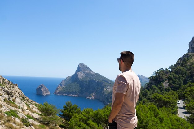 Nicht erkennbarer junger Mann auf dem Rücken mit Blick auf das Mittelmeer in Mallorca Spanien