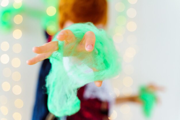 Nicht erkennbares Kind, das zu Hause mit gruseligem Halloween-Spinnennetz spielt