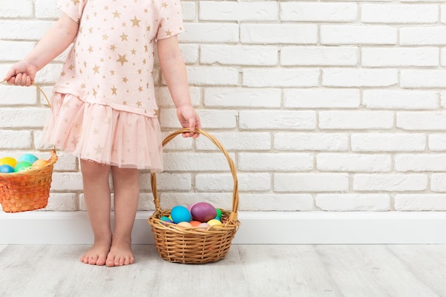 Nicht erkennbares Mädchen mit bunten Ostereiern in zwei Weidenkörben