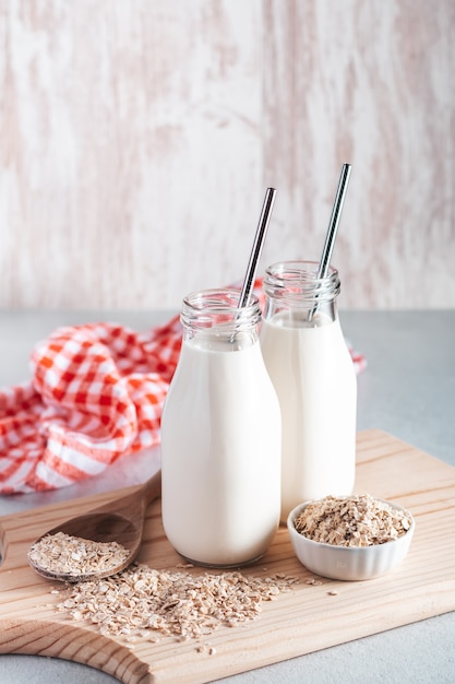 Nicht milchhaltige Hafermilch in Gläsern mit wiederverwendbaren Metallstrohhalmen. Gesundes veganes Milchalternativenstillleben, Kopienraum. Ersatz für traditionelle Kuhmilch mit Haferflocken, gesundes Lebensstilkonzept