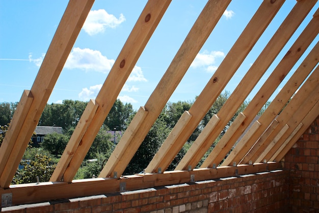 Foto nicht mit keramikziegeln belegte dachstühle am einfamilienhaus im bau, sichtbare dachelemente, lattung, konterlattung, sparren. industriedachsystem holz, balken und schindeln.