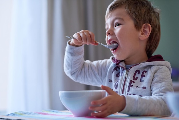 Nichts geht über ein leckeres Frühstück Schnappschuss eines kleinen Jungen, der zu Hause frühstückt