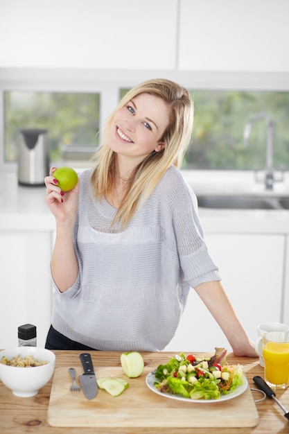 Nichts ist besser, als richtig zu essen und sich großartig zu fühlen. Glückliche junge Frau, die zu Hause gesunde Lebensmittel auswählt