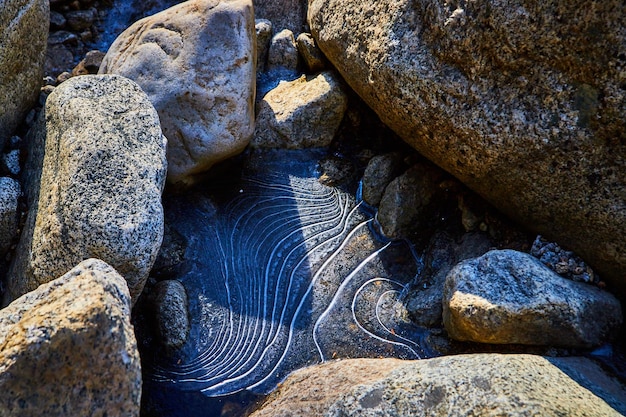 Único y hermoso detalle de formación de hielo ondulado entre rocas