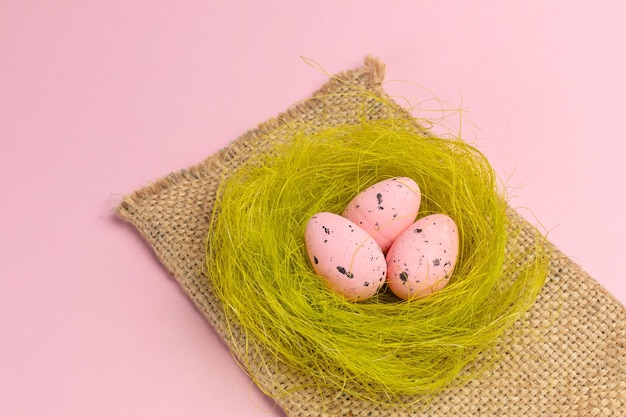 Foto nido con huevos de pascua de colores en la bolsa de saco.