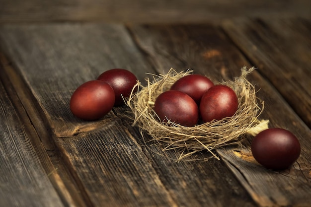 Un nido natural con huevos sobre un fondo de madera oscura.