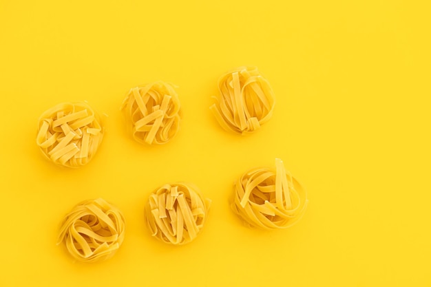Nidos de pasta italiana sobre fondo amarillo