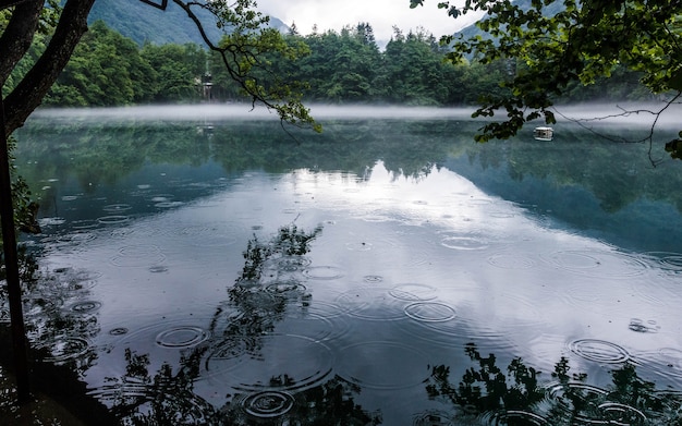 La niebla se extiende sobre la superficie del lago kárstico azul Cerik-Kel en tiempo nublado, República Kabardino-Balkar, Rusia