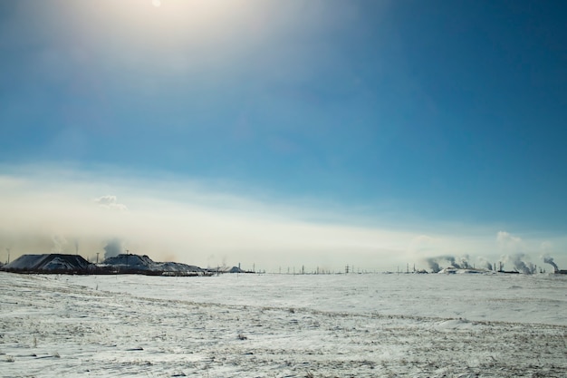 La niebla, el humo de la producción química se esparce por el suelo en un día soleado de invierno.