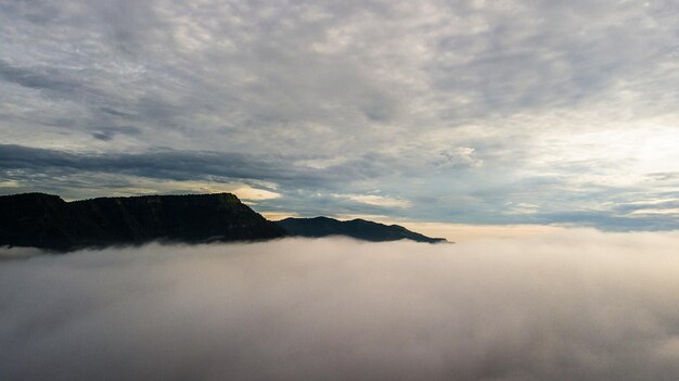 Niebla matutina con amanecer de montaña y mar de mis