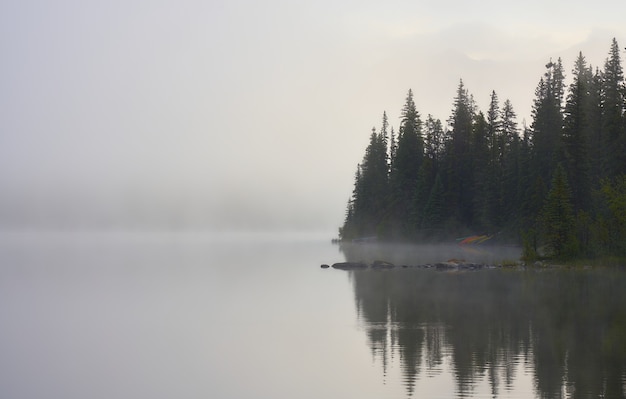 Niebla matutina en Pyramid Lake con canoas en Canadá