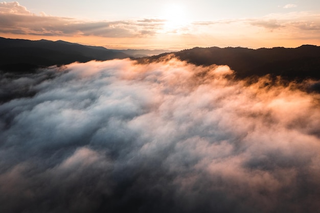 Niebla con montañas y luz por la mañana.