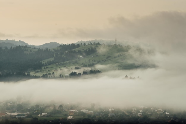 La niebla en el valle del pueblo entre las montañas.