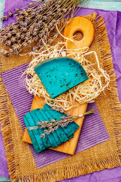 Niederländischer Blauschimmelkäse mit Lavendel auf türkisfarbenem Holzhintergrund