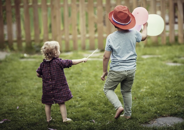 Niedliche Kinder spielen mit Luftballons im Garten