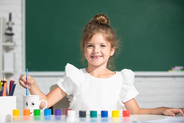 Niedliche kleine Mädchen malen mit Farben Farbe und Pinsel Zeichenstunde in der Schule der frühen Kindheit...