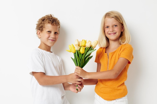 Niedliche stilvolle Kinder mit einem Blumenstrauß Geschenk Geburtstag Urlaub Kindheit hellen Hintergrund