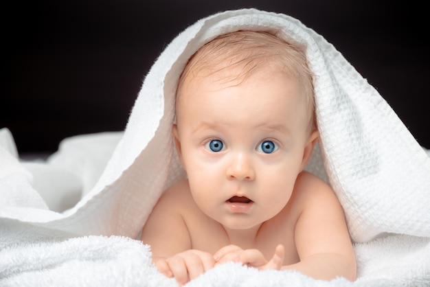 Niedliches Baby mit blauen Augen, Nahaufnahme eines Porträts. Kleiner Junge blickt in die Kamera