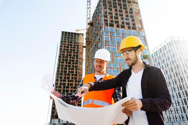 Foto niedrige winkelsicht des mittleren schusses des ingenieurs und des architekten, die bau überwachen