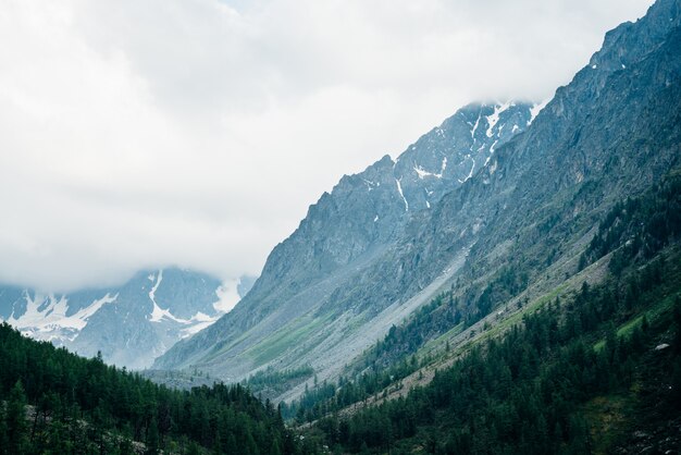 Niedrige Wolken auf riesigen schneebedeckten Felsen