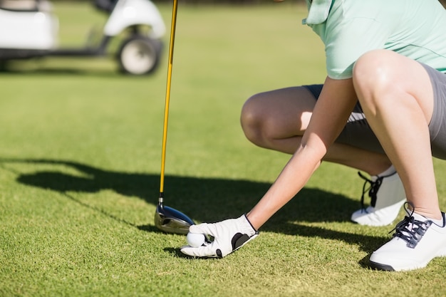 Niedriger Abschnitt der Frau, die Golfball hält