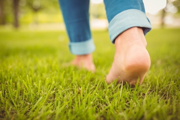 Niedriger Abschnitt der Frau gehend auf Gras