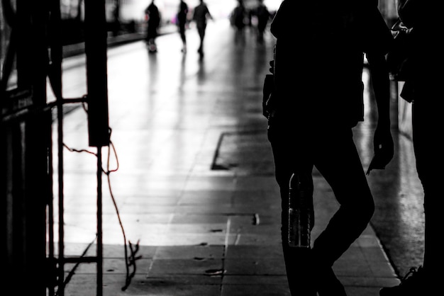 Foto niedriger abschnitt von silhouette-männern, die auf dem bahnhof-platform stehen