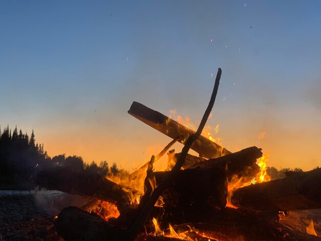 Foto niedriger blickwinkel des lagerfeuers gegen den himmel während des sonnenuntergangs