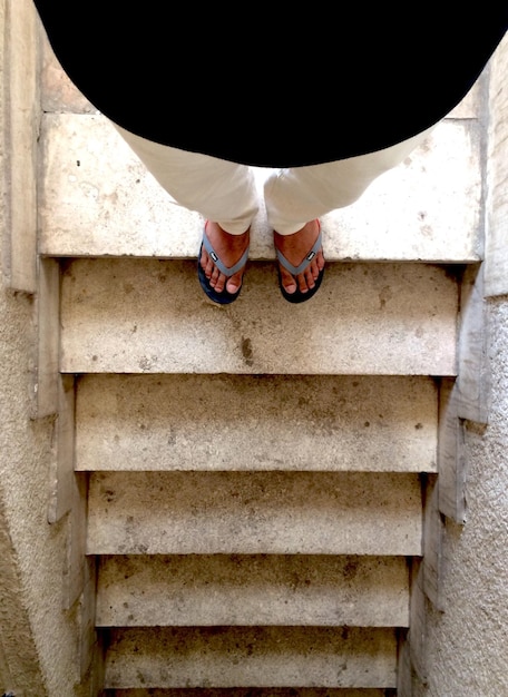 Foto niedriger teil des mannes, der an den treppen steht