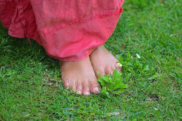 Foto niedriger teil einer frau, die auf dem gras auf dem feld steht