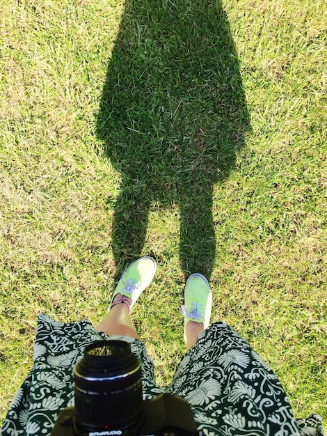 Foto niedriger teil einer frau, die auf einem grasbewachsenen feld steht