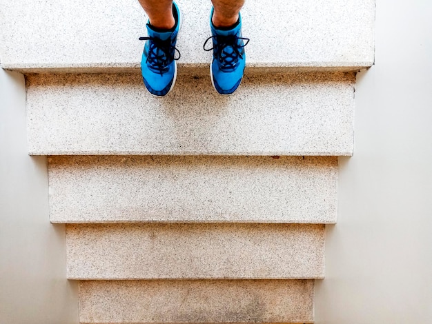 Foto niedriger teil einer person, die auf einer treppe steht